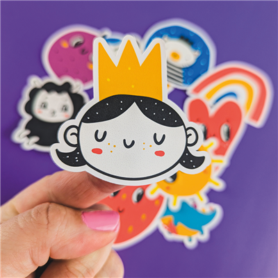 Sticker of a cartoon girl with a crown held by a hand against a colorful background